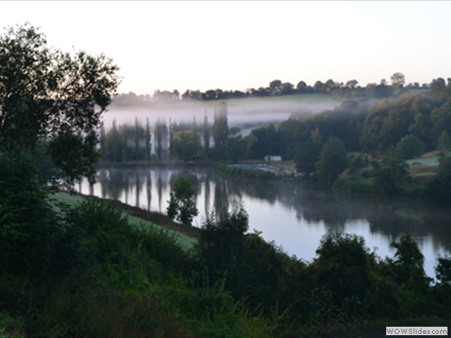 Low early morning mist over the lake in Vimoutiers